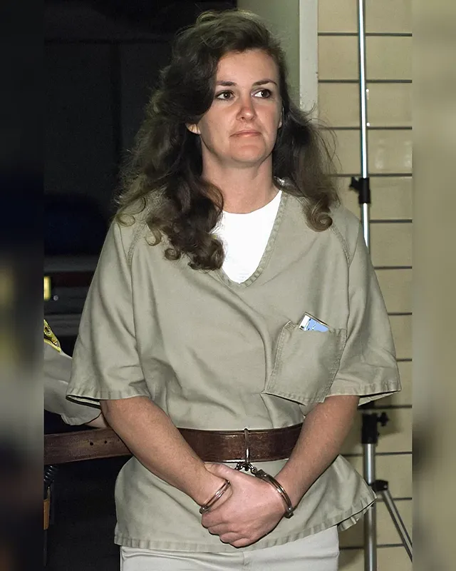 Patricia Rorrer.Back in the early 90's this woman was arrested on suspicion of a double homicide. Suddenly she was no longer a free woman but an inmate. She was made to wear a drab degrading uniform every single day, constantly had to let herself get locked in restraints, and was routinely forced to undergo deeply humiliating pat downs and stripsearches. And sadly for her now, more than three long decades later, she still has to live like this. That is because she was found guilty and sentenced to life without parole. So she will never get released again, never get to be a free woman again, and never get to set a single foot out of her cellblock again without being helplessly locked in a full set of restraints. It is a pathetic and miserable life, but of course she has absolutely no one to blame for it but herself. She is a murderer, so this is simply what she deserves.#handcuffs #handcuffed #handcuffedwoman #handcuffedgirl #shackled chained inmate court sentenced arrested prison jail