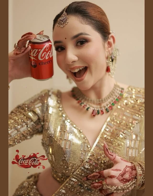 She’s giving total bridal glam meets fun energy vibes! 🔥✨The gold outfit is stunning all those sequins and mirror work catching the light, the jewels, the mehndi… and then just casually holding a Cherry Coke like a queen 😄😍It’s that perfect mix of traditional elegance + cool personality that makes wedding photos truly memorable. She clearly knows how to have fun while looking absolutely gorgeous! 👑♥️. Beautiful @sumaiyaa.a Adorable Captures by @tarkikborahphotography Makeup @makeupartist_raghu_rekx Mehendi @mehendi_artist_purvie Location and outfit @theluxeloomghy Your Favourite @witty_wedding #wittywedding #bridalinspirations #coke #cococola #happybride by @witty_wedding
