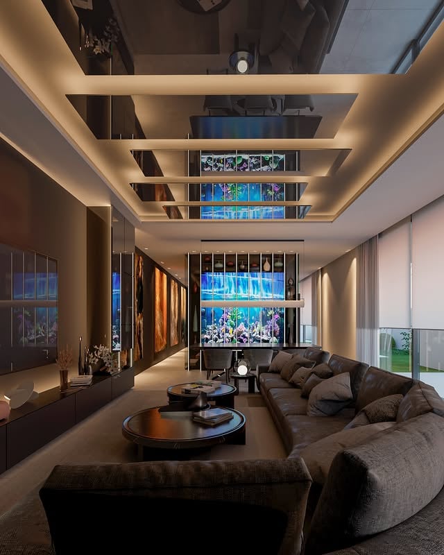 Este proyecto se ha planteado buscando que toda la vivienda tenga una continuidad visual y una sensación de equilibrio entre unas estancias y otras. La idea era crear espacios amplios y conectados, con una estética contemporánea y muy cuidada, donde cada elemento tuviera protagonismo, pero manteniendo una línea común en toda la casa.

La propuesta gira alrededor de una paleta de materiales neutros y elegantes, combinando tonos oscuros con texturas más cálidas y piezas de piedra natural que aportan contraste y profundidad. La iluminación también tiene un papel muy importante dentro del proyecto, no solo desde un punto funcional, sino como parte del diseño, acompañando la arquitectura, resaltando volúmenes y ayudando a generar distintas atmósferas según cada espacio.

También se buscó que el arte y algunas piezas más singulares (como la pecera) estuvieran integradas dentro del propio diseño, aportando personalidad y haciendo que cada estancia tenga carácter propio. En conjunto, el proyecto transmite una imagen contemporánea y sofisticada, pero a la vez muy habitable, con espacios pensados para disfrutarlos desde la calma, la luz y la comodidad en el día a día.