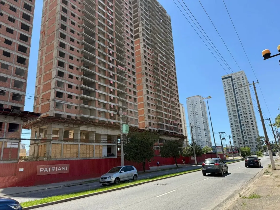 COM PREJUÍZO DE R$ 323,9 MILHÕES EM 2025, PATRIANI DEIXA DE SER CONSTRUTORA E FOCA EXCLUSIVAMENTE EM INCORPORAÇÃO IMOBILIÁRIA

Após gestão de crise e em uma nova etapa do processo de reestruturação da Patriani, a empresa deixará de executar obras diretamente para atuar exclusivamente como incorporadora. A mudança faz parte do plano conduzido pelo fundador, Valter Patriani, que retornou à gestão da companhia com o objetivo de reorganizar as operações e concluir os empreendimentos em andamento.

A retomada prevê a transferência gradual das obras para construtoras parceiras e a realocação dos cerca de 1.500 colaboradores atualmente vinculados às operações de construção. Apesar de restarem apenas 50 profissionais desse total na empresa, o empresário não fala em demissões, já que haverá transferência de funcionários.

“Esses funcionários que não ficaram na incorporadora foram direcionados às constutoras que assumiram as obras”, disse Valter Patriani em entrevista ao nosso canal.

A empresa fechou 2025 com prejuízo de R$ 323,9 milhões, após registrar lucro de R$ 4,4 milhões no ano anterior. A receita recuou 61%, situando-se em R$ 508,1 milhões. “Na verdade, esse resultado de prejuízo também ocorreu porque pegamos tudo o que tínhamos, inclusive problemas de 2026, para colocar no balanço geral e melhorar a vida daqui para frente. A Patriani é uma boa marca e vamos seguir a vida confiantes de que as coisas vão melhorar”, afirmou.

Ele relata que 75% dos problemas já estão resolvidos e faz questão de tranquilizar os clientes, afirmando que ninguém ficará sem atendimento e solução. “Estamos procurando todos os clientes para darmos continuidade à entrega de todas as obras.”

Ainda de acordo com o fundador, o ano de Copa do Mundo seguido de eleições atrapalha de certa forma por conta das incertezas. “A eleição é um problema. Claro que o Brasil é um país espetacular, mas a questão maior é a elevação das taxas de juros e os gastos do governo. A classe média se ressente, e é inegável que as vendas ficam mais nervosas.”

Atualmente, a Patriani tem 20 obras em andamento, e a maior parte delas já foi transferida para outras constutoras.

#patriani #construtora #crise